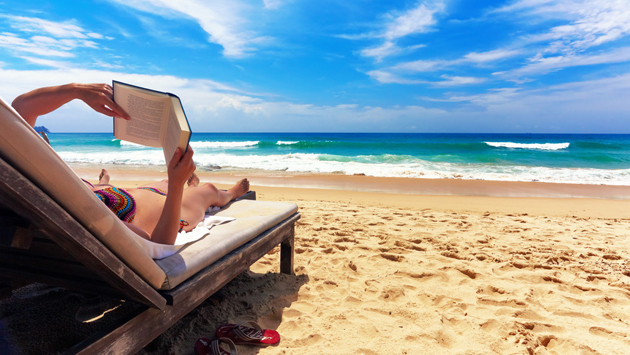 woman-reading-book-at-beach